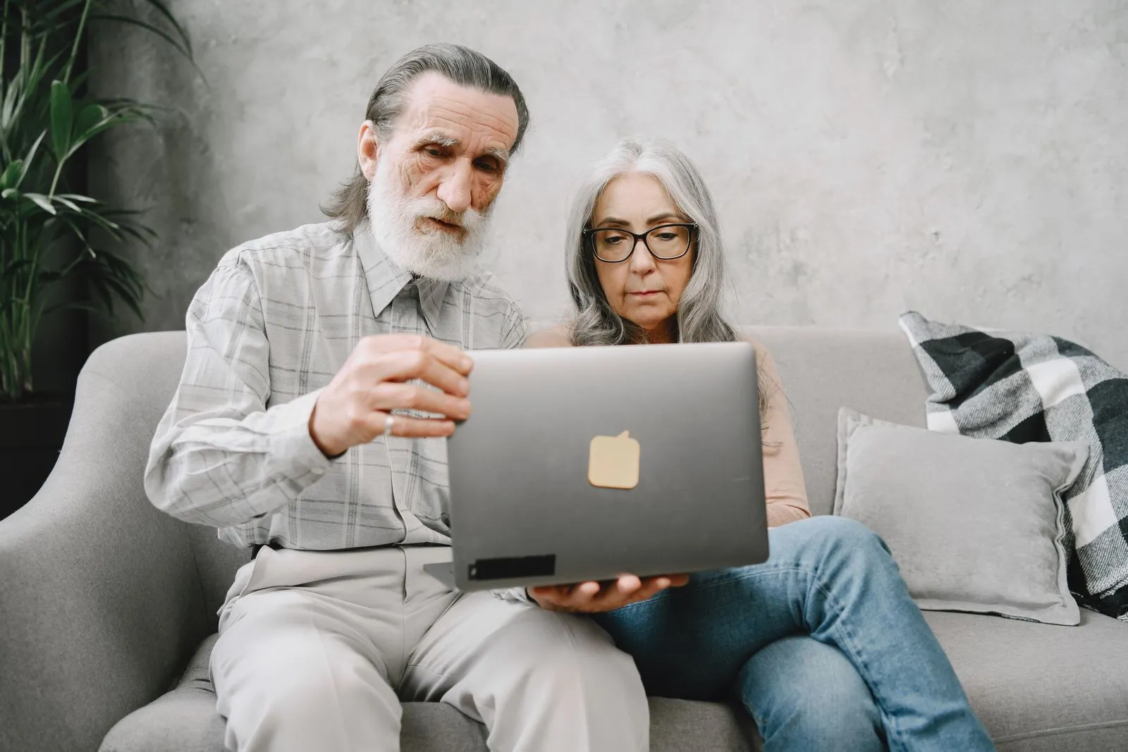 Two adults using a laptop together at home